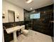 Modern bathroom with marble accents, glass shower, pedestal sink, and stylish fixtures at 1399 Aloma Ave, Winter Park, FL 32789