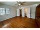 Bedroom with wood floors, a ceiling fan, and access to closets and bathroom through open doors at 1399 Aloma Ave, Winter Park, FL 32789