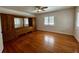 Bedroom with wood floors, a ceiling fan, and a large built-in headboard and storage unit at 1399 Aloma Ave, Winter Park, FL 32789