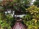 Charming gazebo in a lush garden with mature trees and flowering plants, creating a tranquil retreat at 1399 Aloma Ave, Winter Park, FL 32789