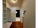 Hallway with hardwood floors, built-in shelves, and an archway leading to a bathroom at 1399 Aloma Ave, Winter Park, FL 32789