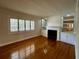 Bright living room with gleaming hardwood floors, fireplace, and natural light through shuttered windows at 1399 Aloma Ave, Winter Park, FL 32789