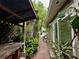 Narrow side yard with lush greenery, a covered structure, and a glimpse of the home's exterior at 1399 Aloma Ave, Winter Park, FL 32789