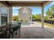Relaxing backyard patio featuring a pool, dining area, and cozy outdoor living space with brick pavers and charming string lights at 14025 Hench Ln, Orlando, FL 32827