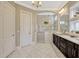 Bright bathroom featuring a marble countertop, dual sinks, a spacious glass shower, and decorative windows at 14025 Hench Ln, Orlando, FL 32827