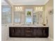 Bright bathroom featuring a marble countertop, dual sinks, a spacious glass shower, and decorative windows at 14025 Hench Ln, Orlando, FL 32827