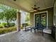 Covered patio with a seating area, ceiling fan, and view of the lush backyard, ideal for outdoor relaxation at 14025 Hench Ln, Orlando, FL 32827