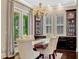 Formal dining room showcases a chandelier, wine cabinets, floor to ceiling windows and hardwood floors at 14025 Hench Ln, Orlando, FL 32827
