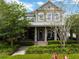 Charming two-story home with covered front porch, stone accents, and lush landscaping creating curb appeal at 14025 Hench Ln, Orlando, FL 32827
