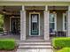 Welcoming front porch with stone pillars, seating, and a beautifully landscaped entryway to a charming home at 14025 Hench Ln, Orlando, FL 32827