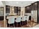 This kitchen features dark cabinets, stainless steel appliances, a tile backsplash, and an island with seating at 14025 Hench Ln, Orlando, FL 32827