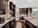 This expansive kitchen features granite countertops, stainless steel appliances, dark cabinets, and tile backsplash at 14025 Hench Ln, Orlando, FL 32827