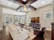 The living room features dark wood floors, a beamed ceiling with ceiling fan, and large windows at 14025 Hench Ln, Orlando, FL 32827