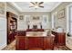 This home office features wood cabinets, a ceiling fan, wainscoting, and large windows with shutters at 14025 Hench Ln, Orlando, FL 32827