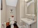Cozy powder room with a pedestal sink, framed mirror, elegant fixtures, and stylish decor, creating a charming space at 14025 Hench Ln, Orlando, FL 32827