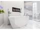 Modern bathroom with free-standing tub, fireplace, and luxurious finishes at 1450 Belfiore Way, Windermere, FL 34786