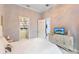 Bedroom featuring a large closet, open door to en-suite bathroom and modern cabinet with TV at 1450 Belfiore Way, Windermere, FL 34786
