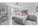 Cozy bedroom features gray walls, tile floor, and plush bedding with a ceiling fan, natural light, and a vanity at 1450 Belfiore Way, Windermere, FL 34786