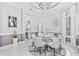 Elegant dining room with a round glass table, chandelier, and stylish decor at 1450 Belfiore Way, Windermere, FL 34786