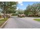 Gated community entrance with lush landscaping, a brick-paved road, and mature trees at 1450 Belfiore Way, Windermere, FL 34786