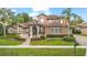 Stunning two-story home featuring a red tile roof, manicured lawn, and lush landscaping at 1450 Belfiore Way, Windermere, FL 34786