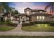 Charming two-story home with a red tile roof, manicured lawn, and mature palm trees at 1450 Belfiore Way, Windermere, FL 34786