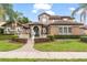 Stunning exterior showcasing a manicured lawn, mature trees, a fountain, and a tile roof at 1450 Belfiore Way, Windermere, FL 34786