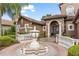 Elegant front entrance featuring a decorative fountain and wrought iron gate at 1450 Belfiore Way, Windermere, FL 34786
