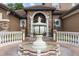 Grand home entrance featuring a custom fountain, arched entryway with columns, and a clay tile roof at 1450 Belfiore Way, Windermere, FL 34786