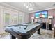 Game room with pool table, modern lighting, and a large screen TV, perfect for entertainment at 1450 Belfiore Way, Windermere, FL 34786