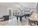 Bright game room featuring a covered pool table, tiled floors, and doors leading to the outdoor space at 1450 Belfiore Way, Windermere, FL 34786