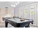 Game room featuring a pool table with modern lighting and access to outdoor views through shuttered french doors at 1450 Belfiore Way, Windermere, FL 34786
