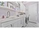 Well-organized laundry room featuring a sink, shelving, updated washer and dryer, and white cabinetry at 1450 Belfiore Way, Windermere, FL 34786