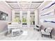 Elegant living room with marble floors, tray ceiling, piano, and abundant natural light at 1450 Belfiore Way, Windermere, FL 34786