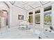 Elegant living room featuring a white piano and marble floors, illuminated by a modern chandelier at 1450 Belfiore Way, Windermere, FL 34786