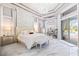 Luxurious primary bedroom with an accent wall, pool view, and stylish furnishings at 1450 Belfiore Way, Windermere, FL 34786
