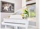 White Yamaha piano with a flower arrangement displayed in front of a sun-filled window at 1450 Belfiore Way, Windermere, FL 34786