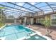 Inviting screened-in pool area with a spa, waterfall feature, and comfortable outdoor living spaces at 1450 Belfiore Way, Windermere, FL 34786