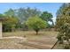 A spacious backyard with mature trees, a wooden deck area, and partial fencing creating a private outdoor retreat at 1503 Canterbury Cir, Casselberry, FL 32707