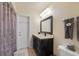 A well lit bathroom features a large mirror, modern vanity, neutral colored walls, and a shower with decorative curtain at 1503 Canterbury Cir, Casselberry, FL 32707