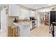 Well-lit kitchen area with white cabinetry, stainless steel dishwasher and views to the dining room at 1503 Canterbury Cir, Casselberry, FL 32707