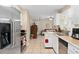 Modern kitchen featuring stainless steel appliances, white cabinets, and tiled backsplash, open to the living area at 1503 Canterbury Cir, Casselberry, FL 32707