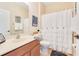 Well-lit bathroom features a modern sink and vanity with a decorative shower curtain at 16313 Birchwood Way, Orlando, FL 32828