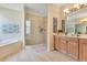 Bright bathroom featuring a soaking tub, glass shower, double vanity, and tile flooring at 16313 Birchwood Way, Orlando, FL 32828