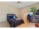 Well-lit bedroom features hardwood floors and a comfortable bed placed next to a window and desk at 16313 Birchwood Way, Orlando, FL 32828