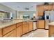 Bright kitchen with stainless steel appliances, granite countertops, and an open view to the living area at 16313 Birchwood Way, Orlando, FL 32828