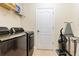 Efficient laundry room with modern washer and dryer and storage shelving at 16313 Birchwood Way, Orlando, FL 32828