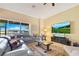 Bright living room showcasing a large window with lake views, a comfortable leather couch, and wood flooring at 16313 Birchwood Way, Orlando, FL 32828