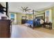 Spacious main bedroom suite with natural light, featuring a canopy bed, ceiling fan, and light wood flooring at 16313 Birchwood Way, Orlando, FL 32828