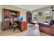 Well-lit home office featuring hardwood floors, a large desk, and comfortable seating area at 16313 Birchwood Way, Orlando, FL 32828